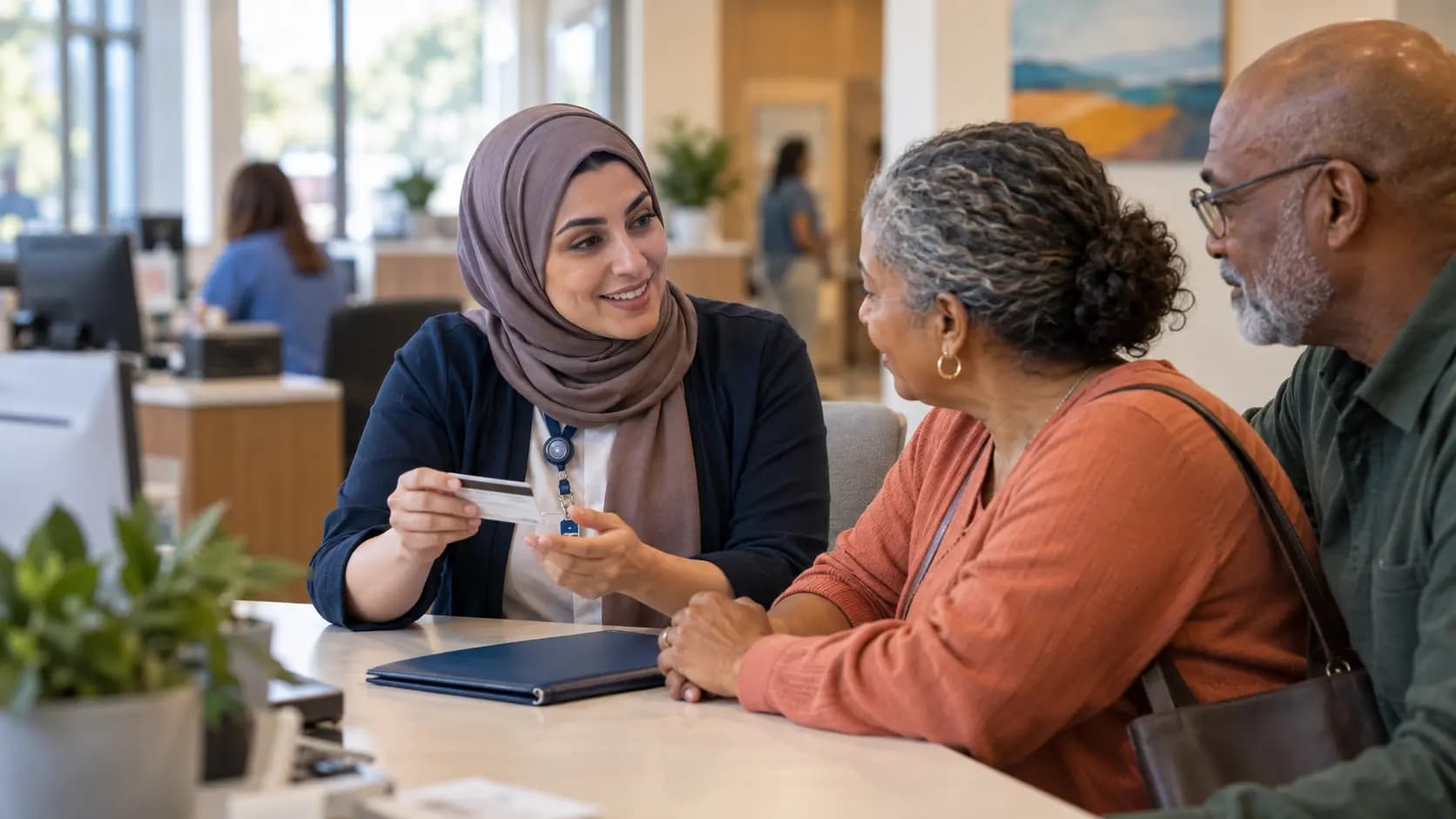 Patient-access coordinator helping a patient at a clinic desk Patient-access coordinator helping a patient at a clinic desk