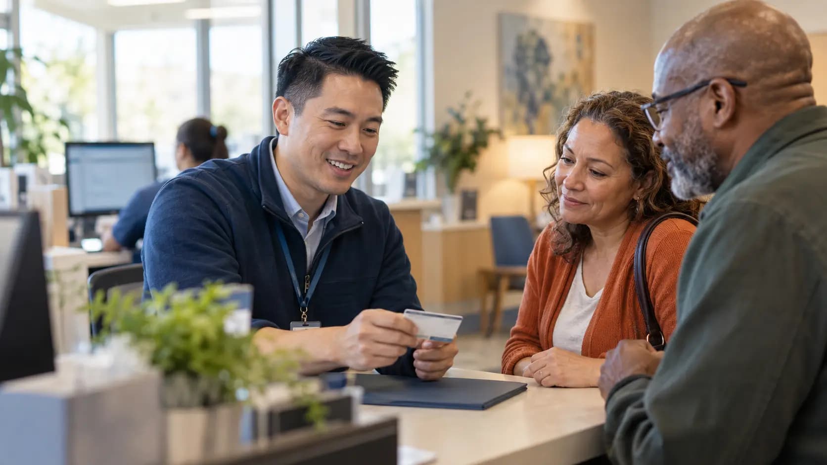 Patient-access coordinator helping a patient at a clinic desk