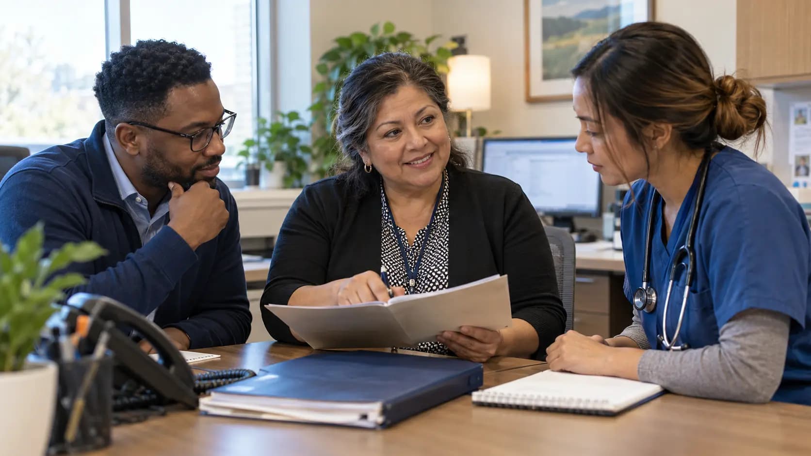 Practice manager and clinician reviewing payer requirements with a specialist