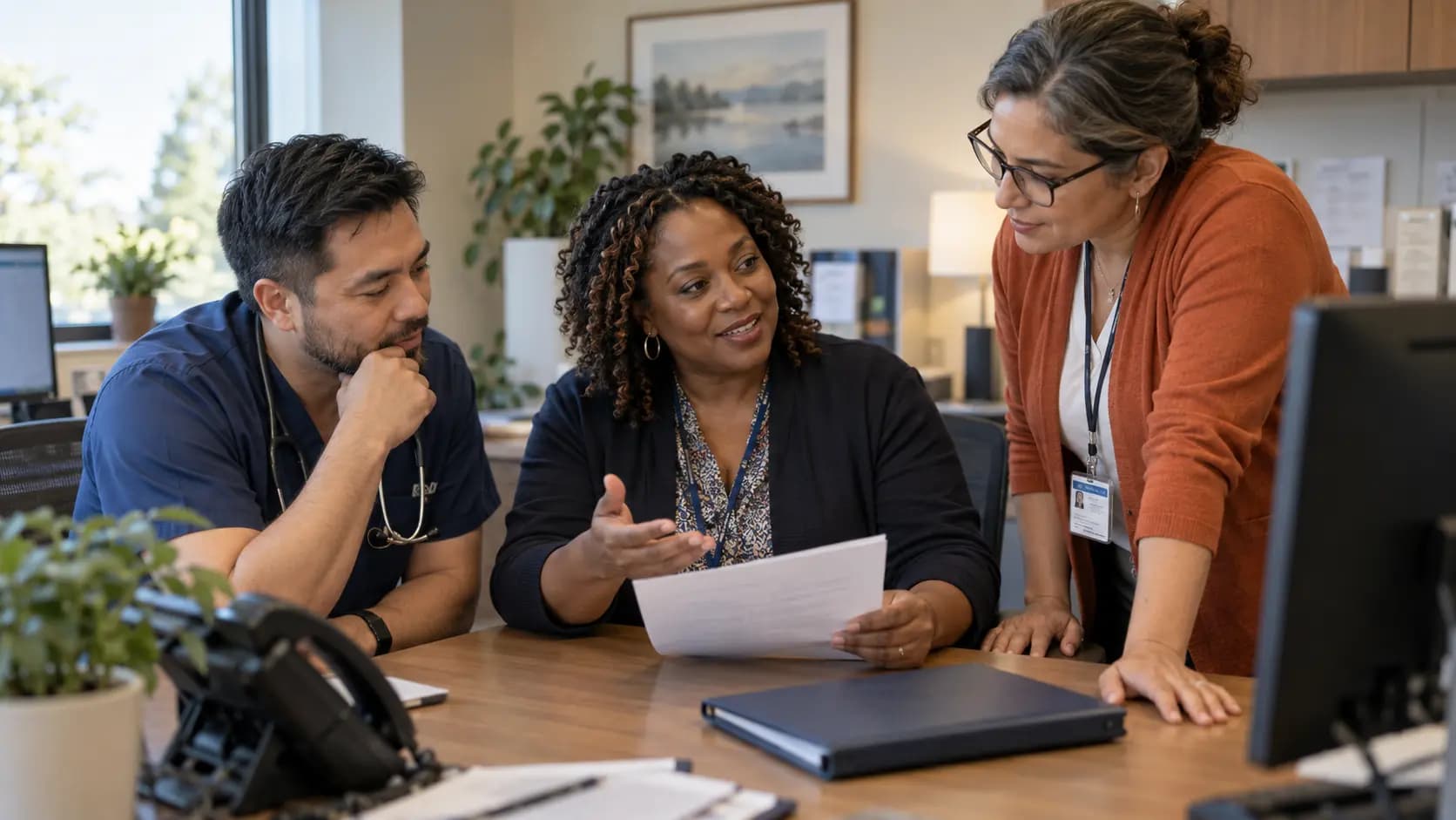 Practice manager and clinician reviewing payer requirements with a specialist