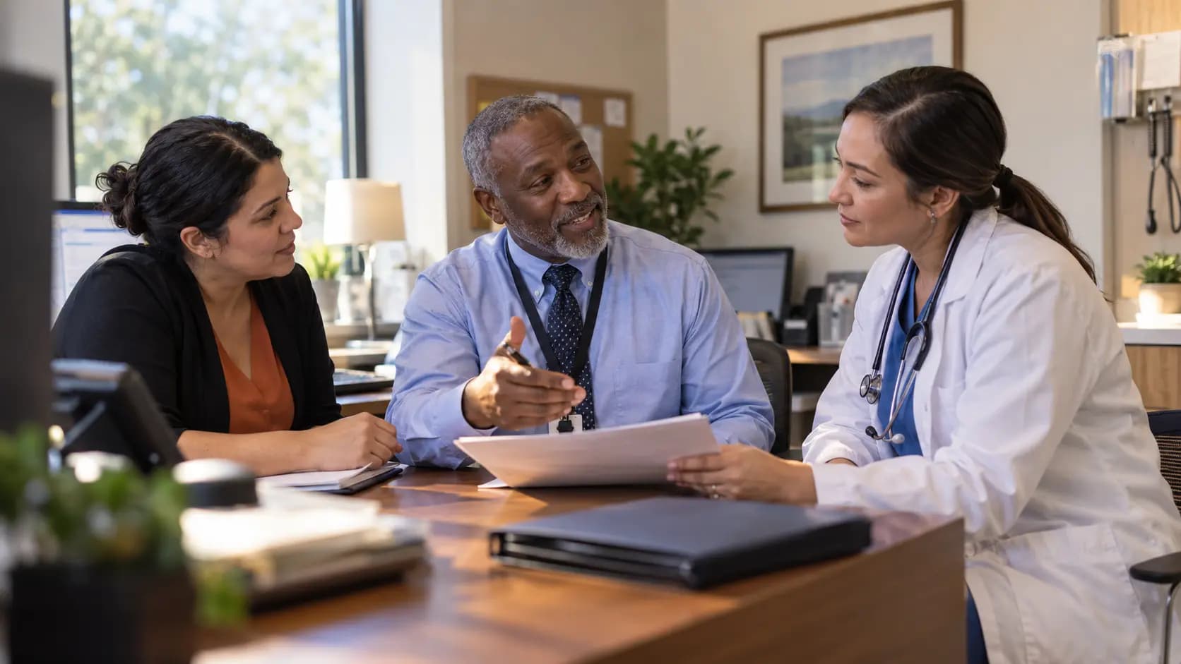 Practice manager and clinician reviewing payer requirements with a specialist