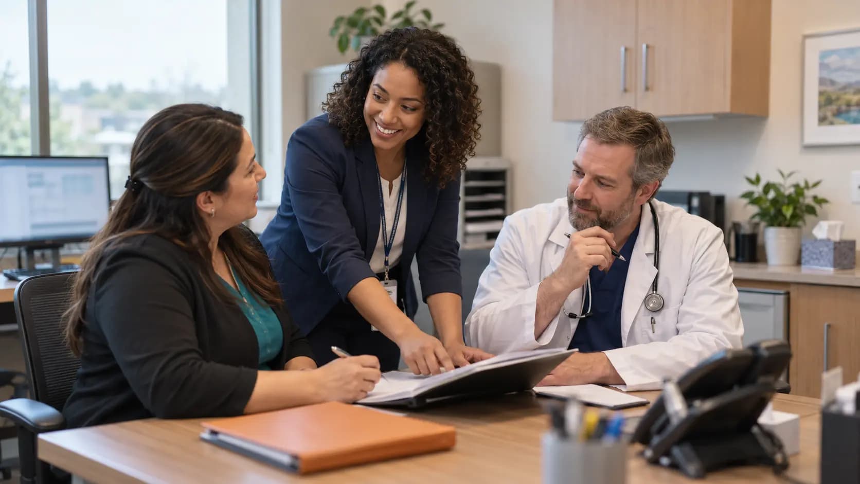 Practice manager and clinician reviewing payer requirements with a specialist