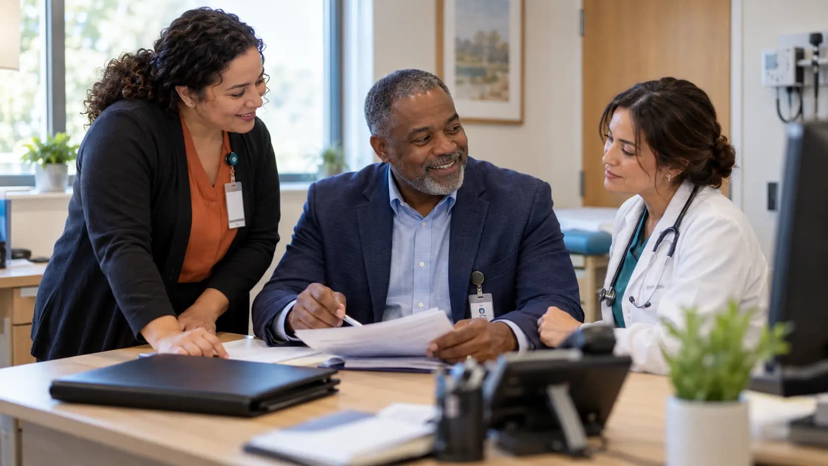 Practice manager and clinician reviewing payer requirements with a specialist