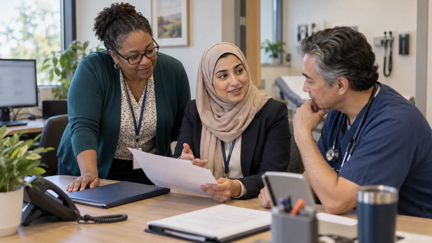 Practice manager and clinician reviewing payer requirements with a specialist