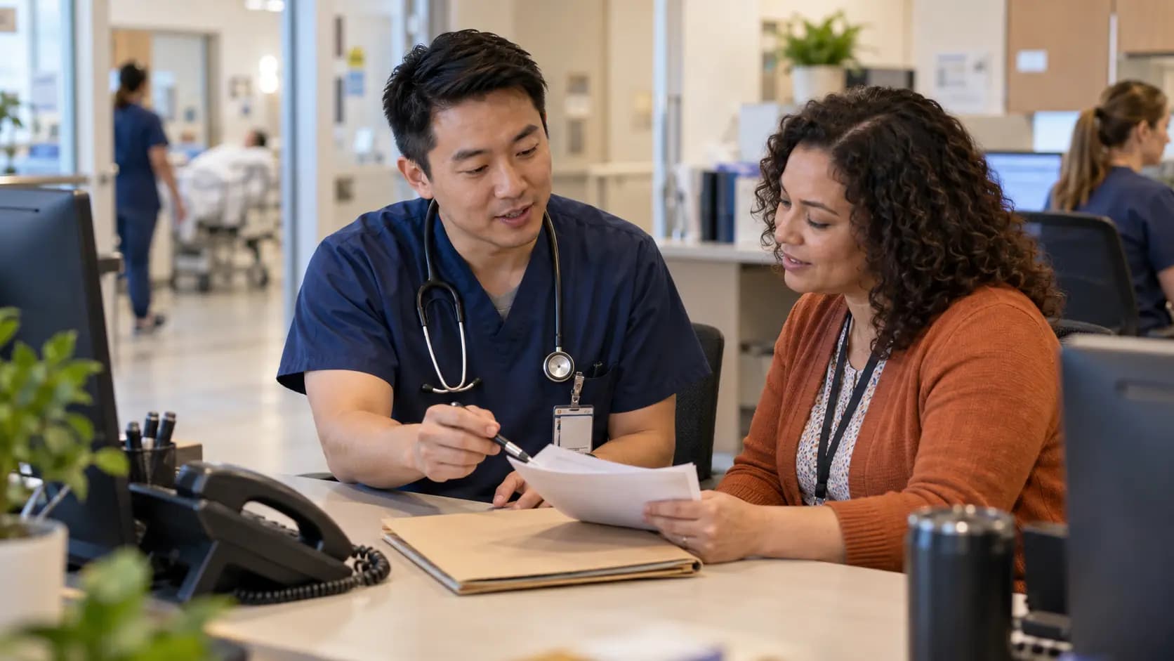 Healthcare colleagues reviewing paperwork together at a clinic desk
