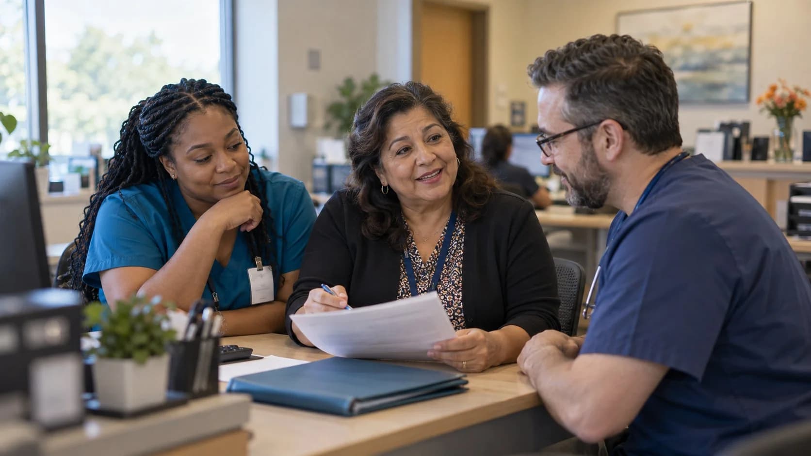 Revenue-cycle educator discussing a workflow with medical-office colleagues