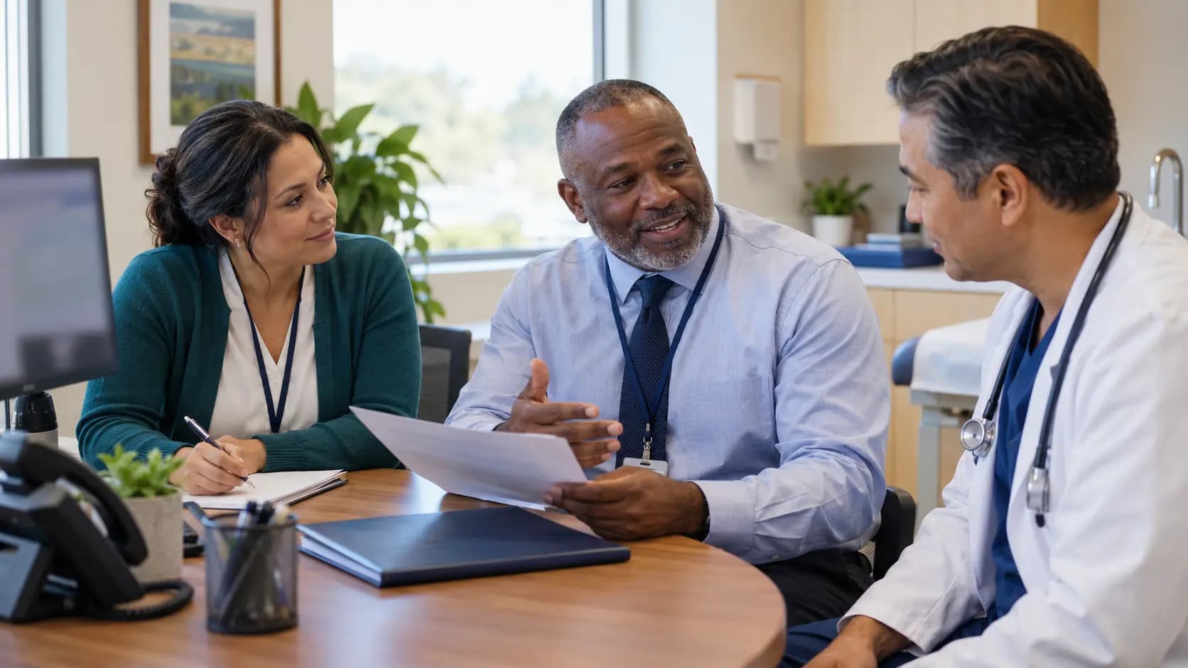Practice manager and clinician reviewing payer requirements with a specialist