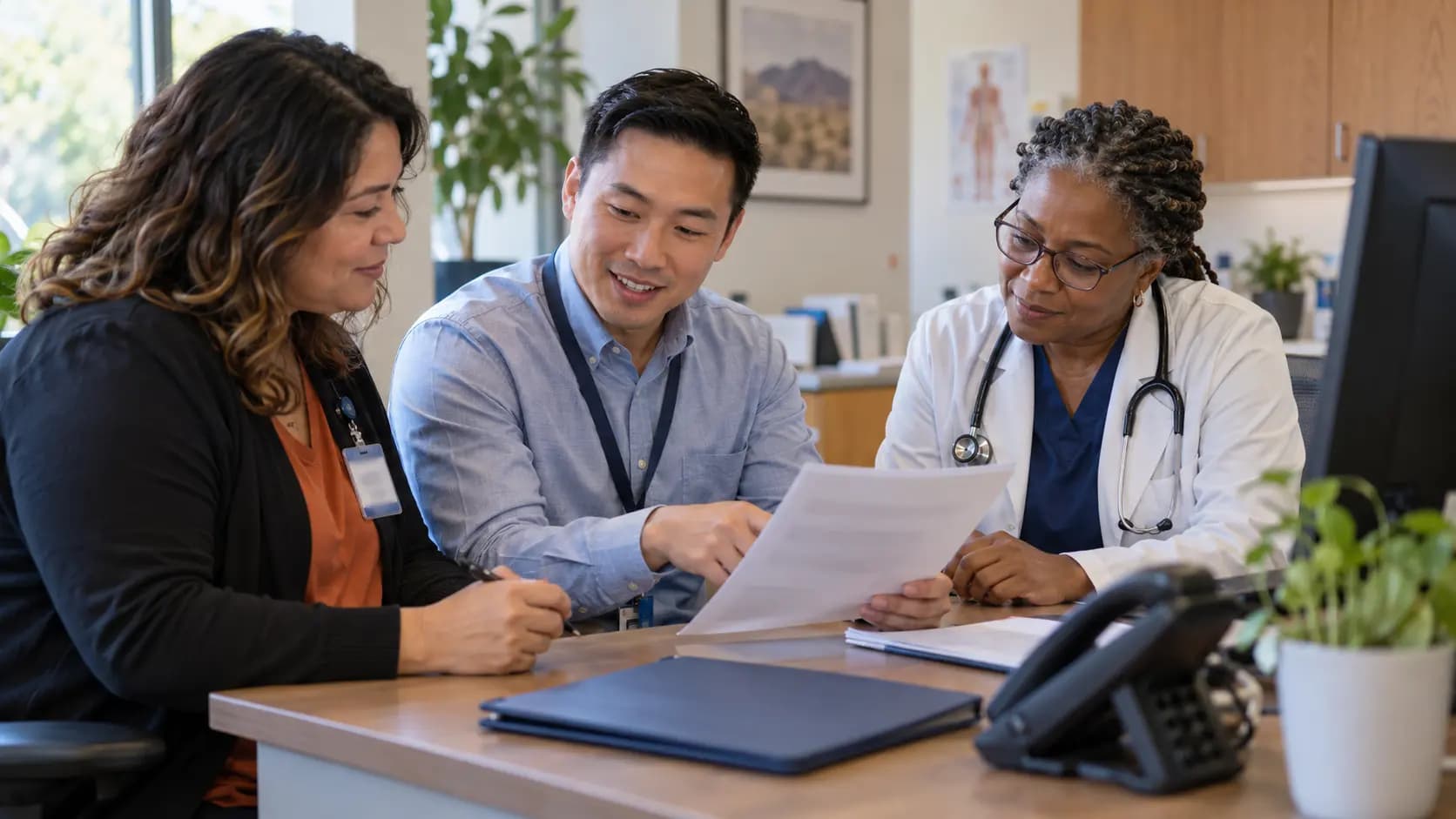 Practice manager and clinician reviewing payer requirements with a specialist