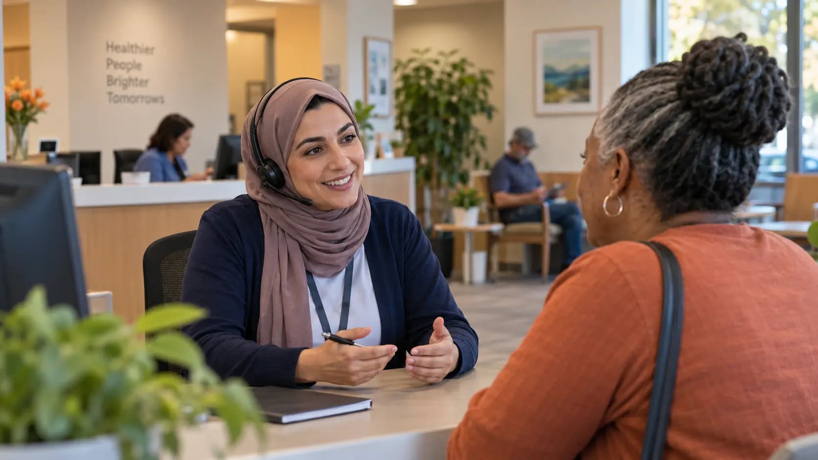Reception colleague wearing a headset and talking with a visitor across a clinic desk Reception colleague wearing a headset and talking with a visitor across a clinic desk