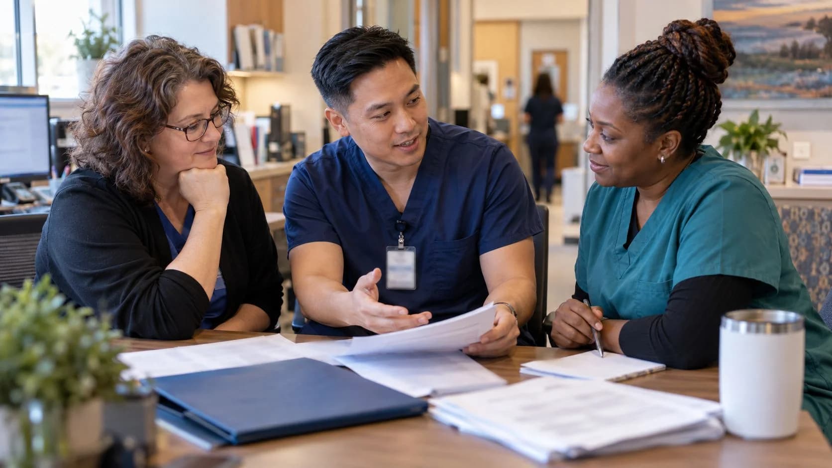 Revenue-cycle educator discussing a workflow with medical-office colleagues