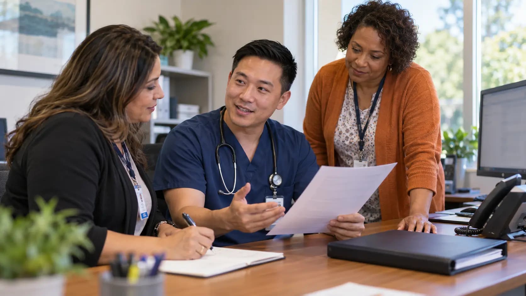 Practice manager and clinician reviewing payer requirements with a specialist