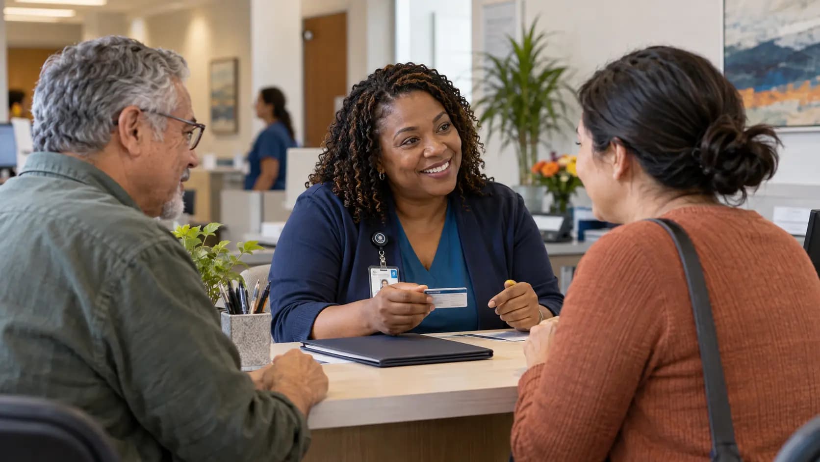Patient-access coordinator helping a patient at a clinic desk