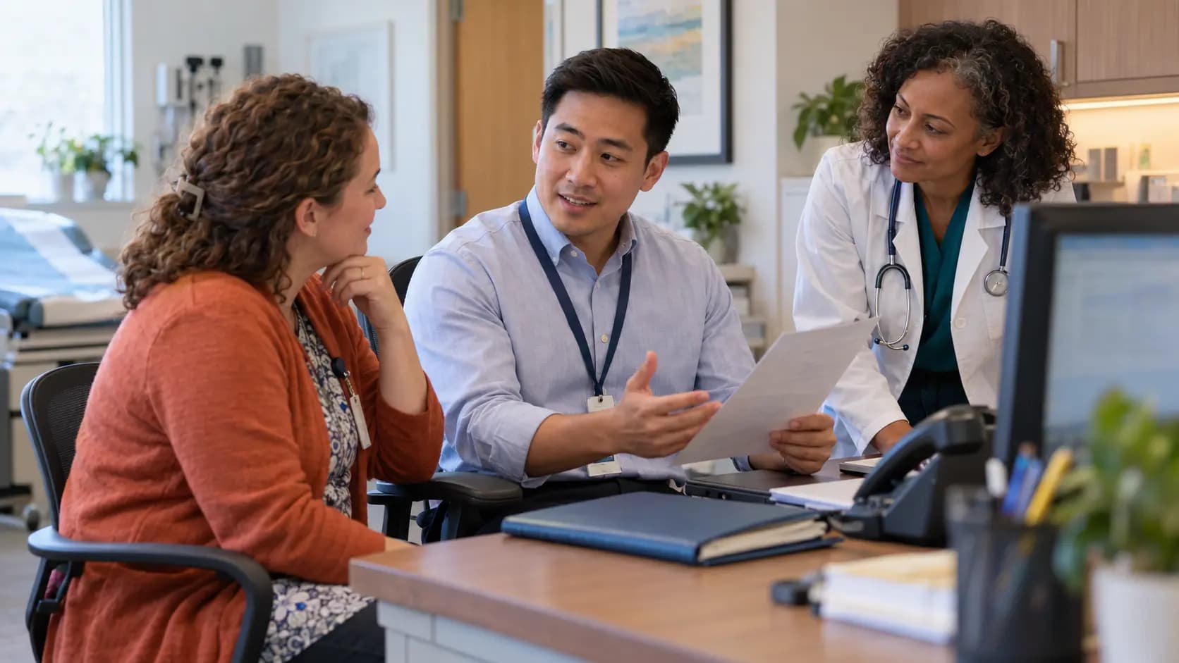 Practice manager and clinician reviewing payer requirements with a specialist