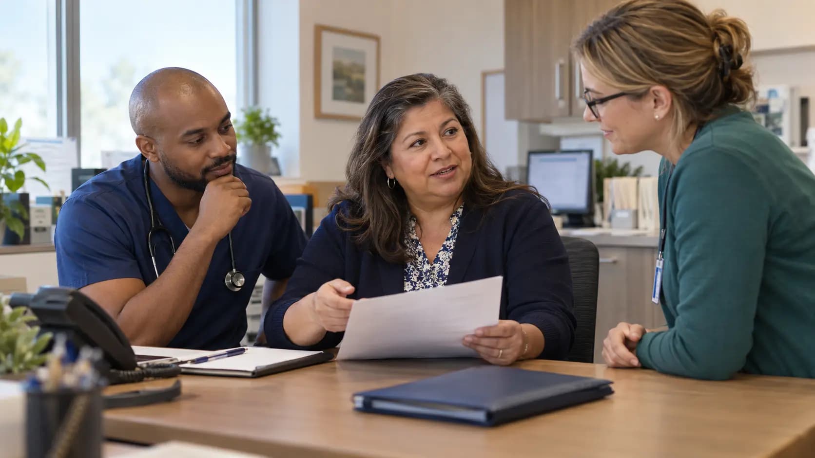 Practice manager and clinician reviewing payer requirements with a specialist