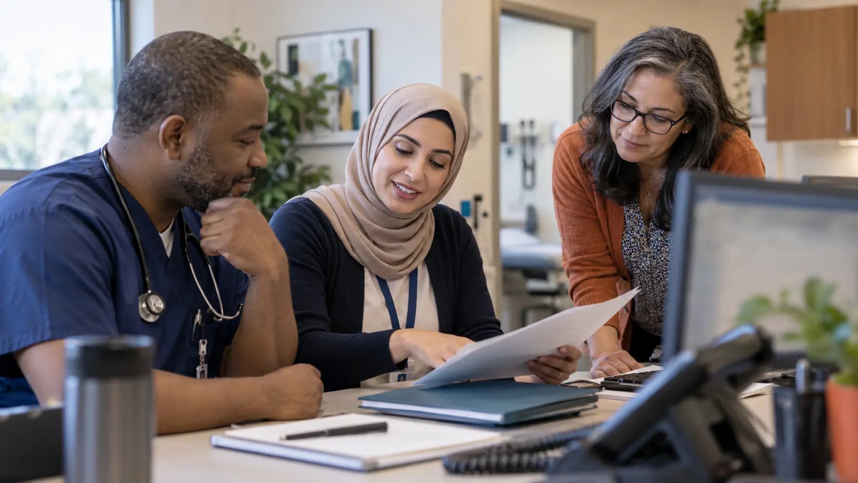 Practice manager and clinician reviewing payer requirements with a specialist