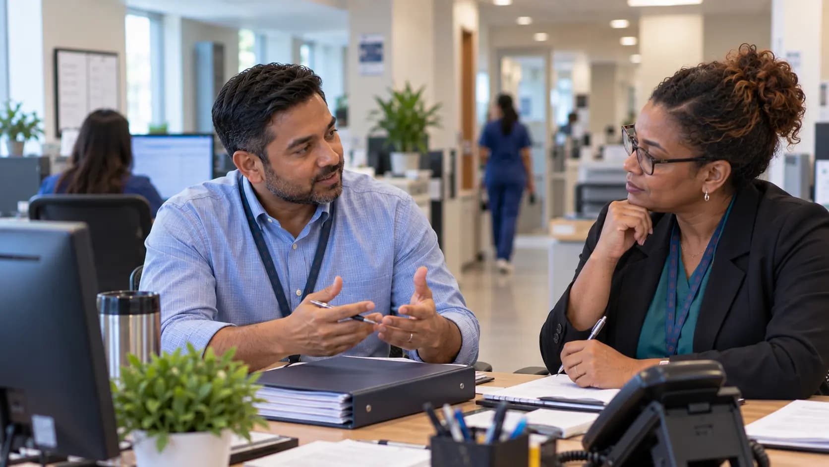 Healthcare colleagues reviewing paperwork together at a clinic desk