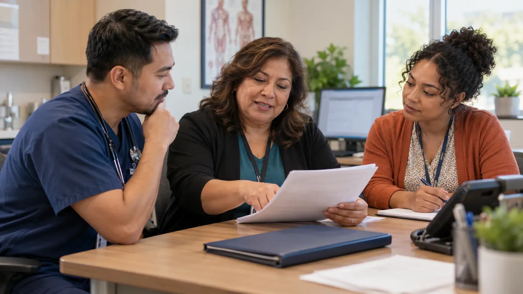 Practice manager and clinician reviewing payer requirements with a specialist