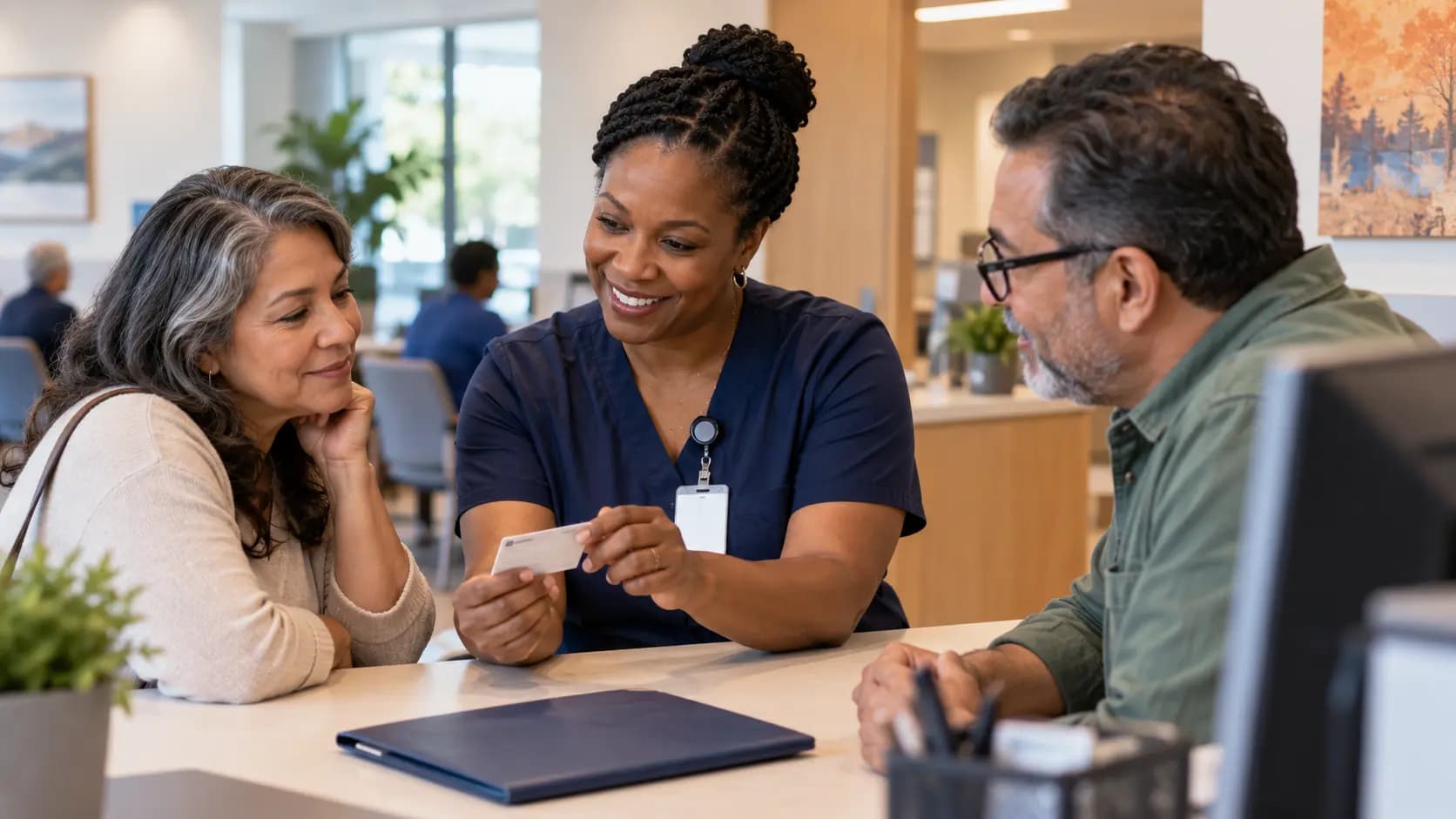 Patient-access coordinator helping a patient at a clinic desk Patient-access coordinator helping a patient at a clinic desk