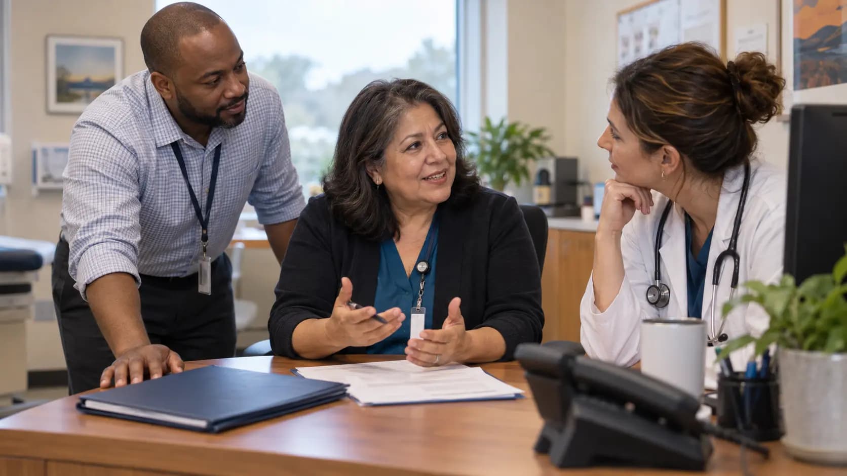 Practice manager and clinician reviewing payer requirements with a specialist