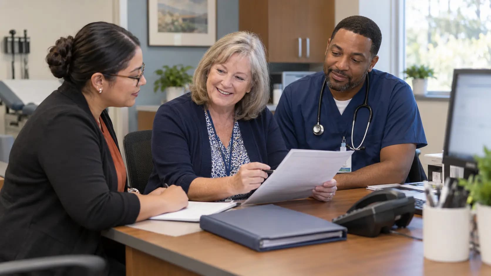 Practice manager and clinician reviewing payer requirements with a specialist