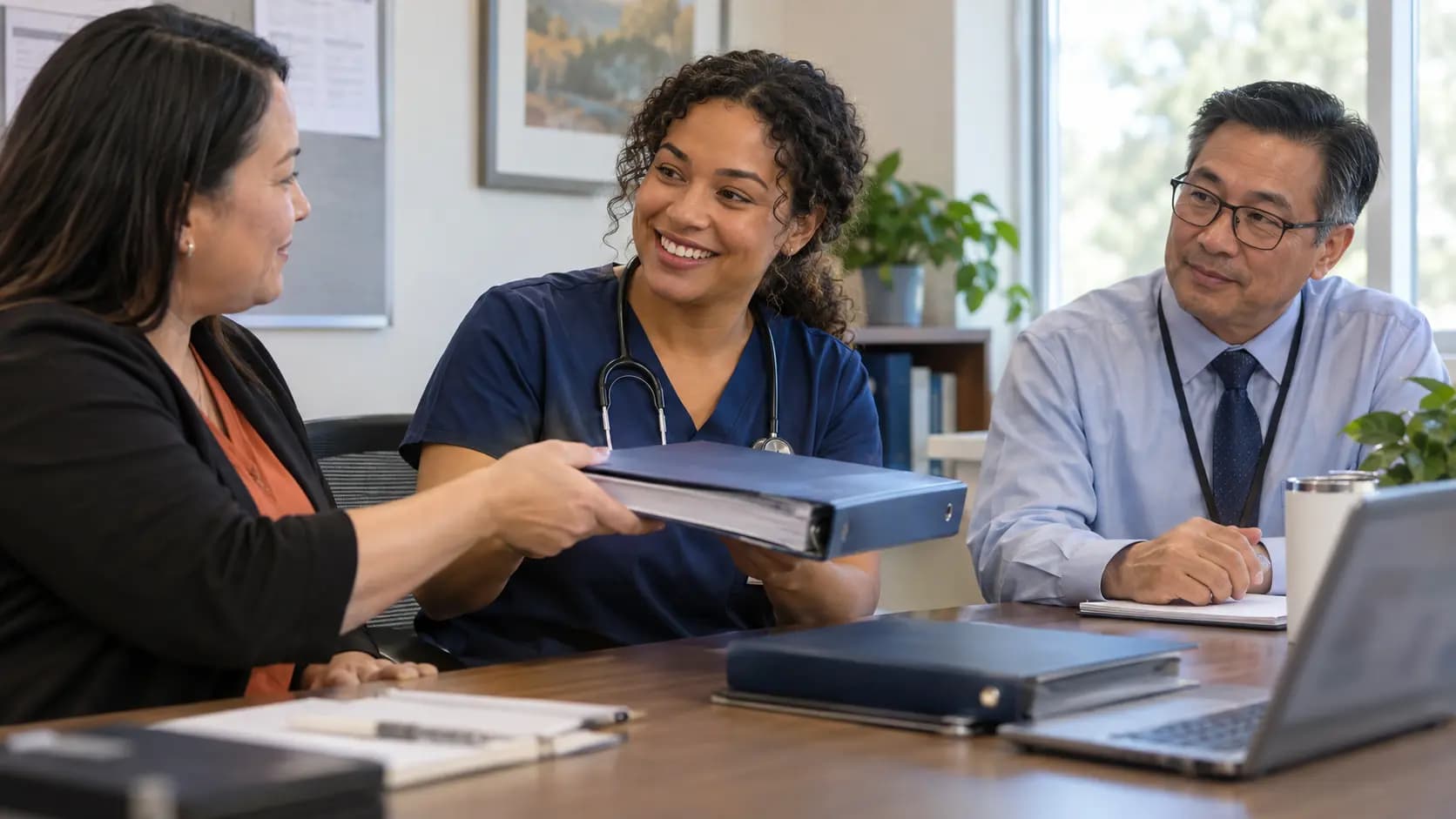 Healthcare compliance officer meeting with a clinician and practice manager