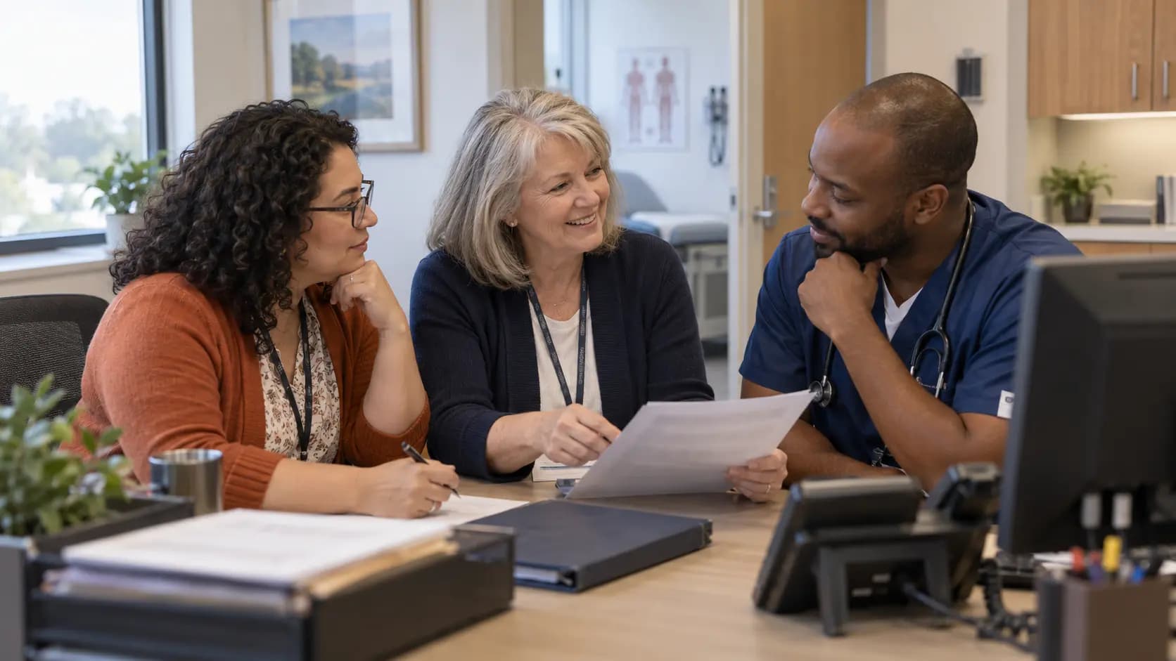 Practice manager and clinician reviewing payer requirements with a specialist