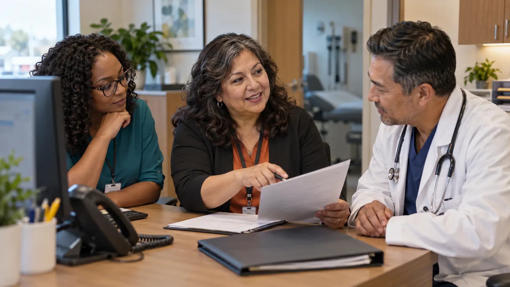 Practice manager and clinician reviewing payer requirements with a specialist