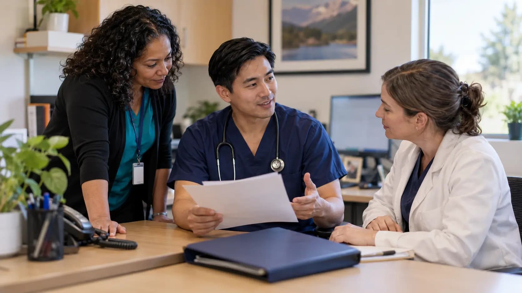 Practice manager and clinician reviewing payer requirements with a specialist