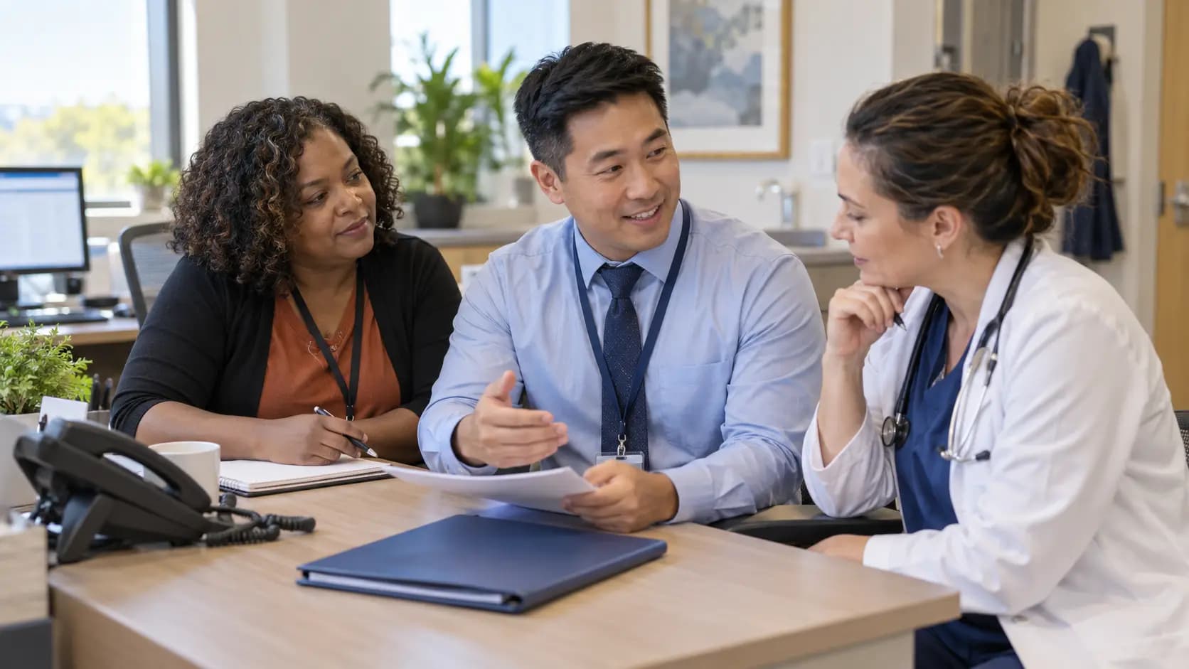 Practice manager and clinician reviewing payer requirements with a specialist