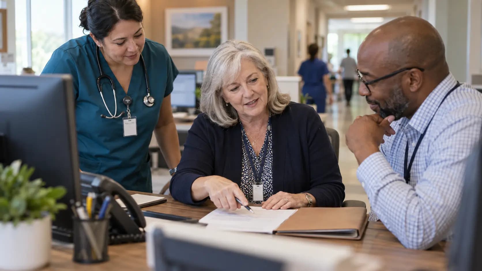 Practice manager and clinician reviewing payer requirements with a specialist