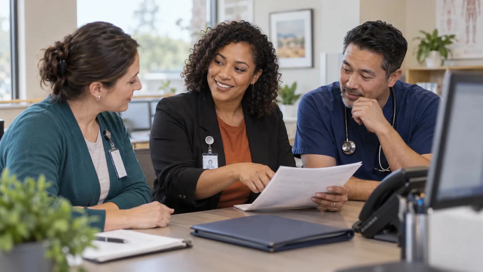 Practice manager and clinician reviewing payer requirements with a specialist