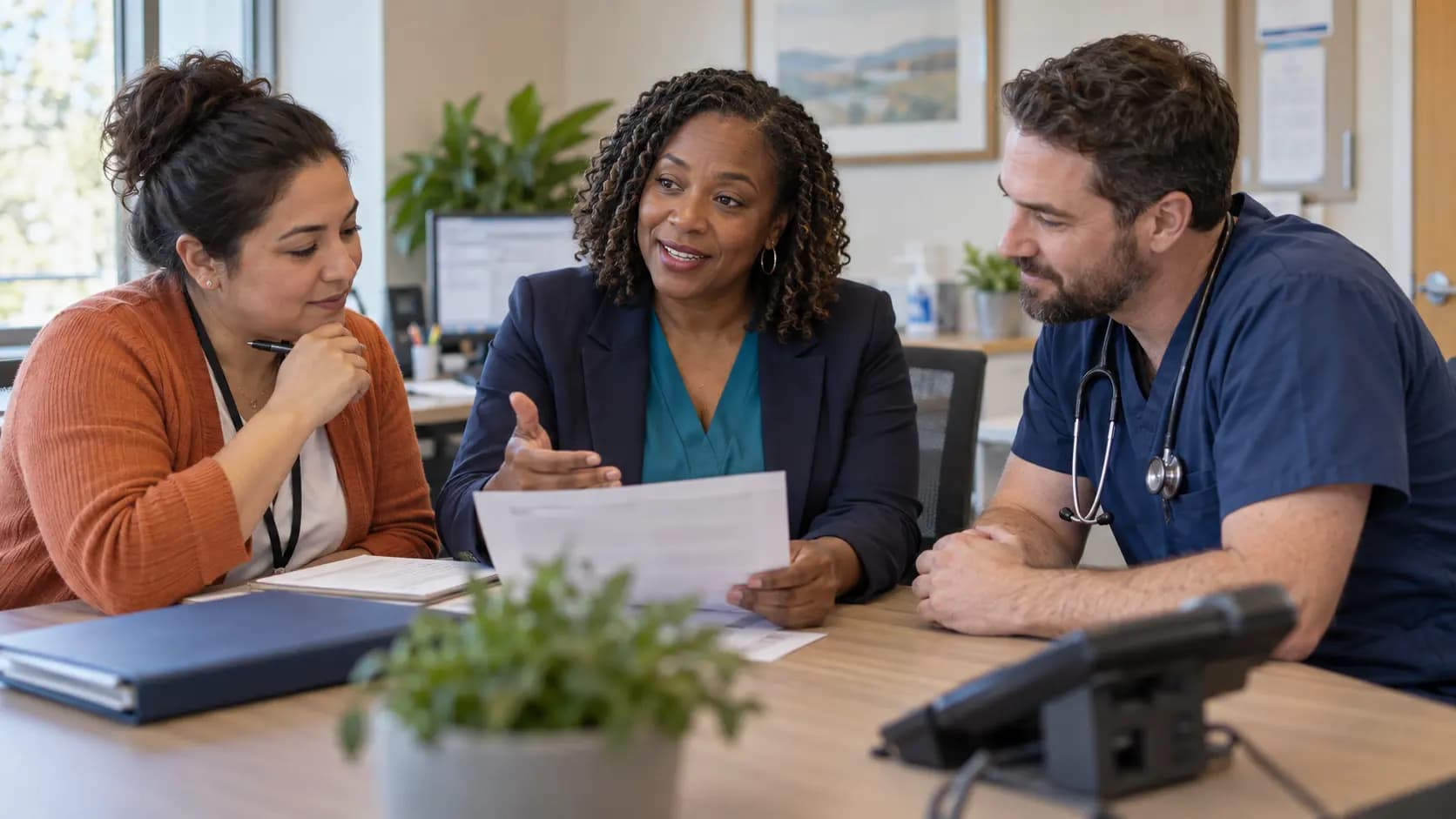 Practice manager and clinician reviewing payer requirements with a specialist