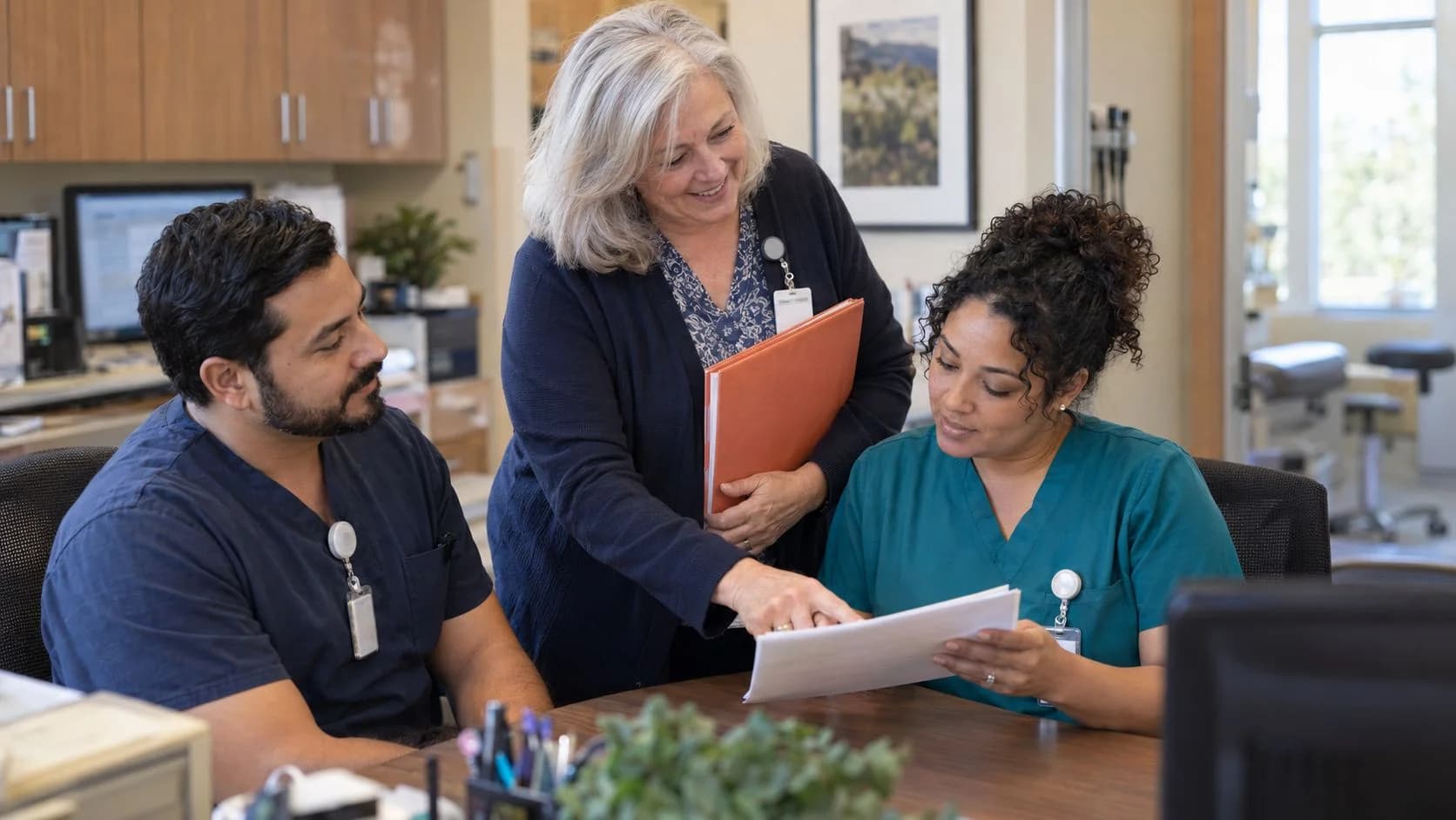Revenue-cycle educator discussing a workflow with medical-office colleagues