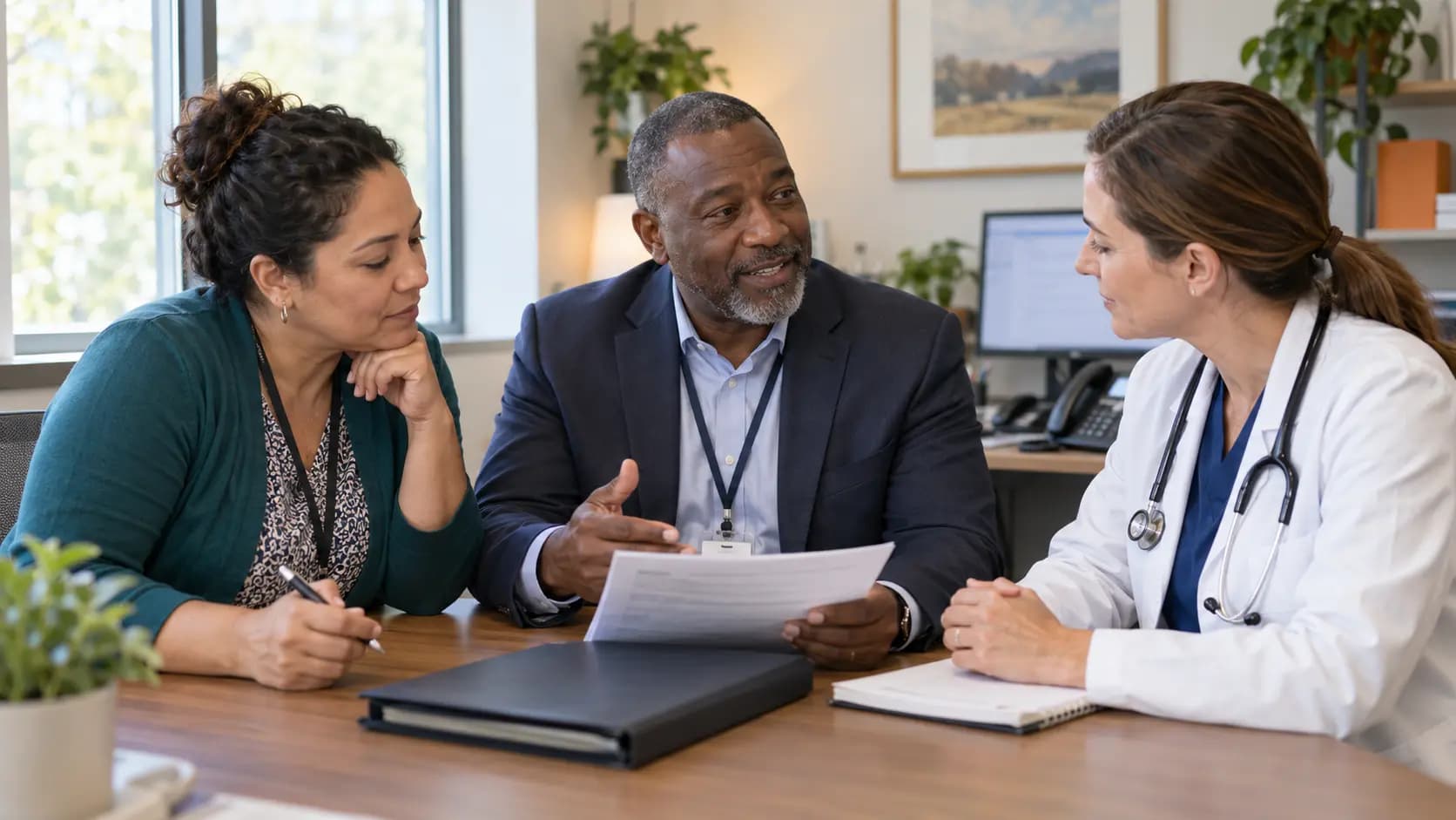 Practice manager and clinician reviewing payer requirements with a specialist