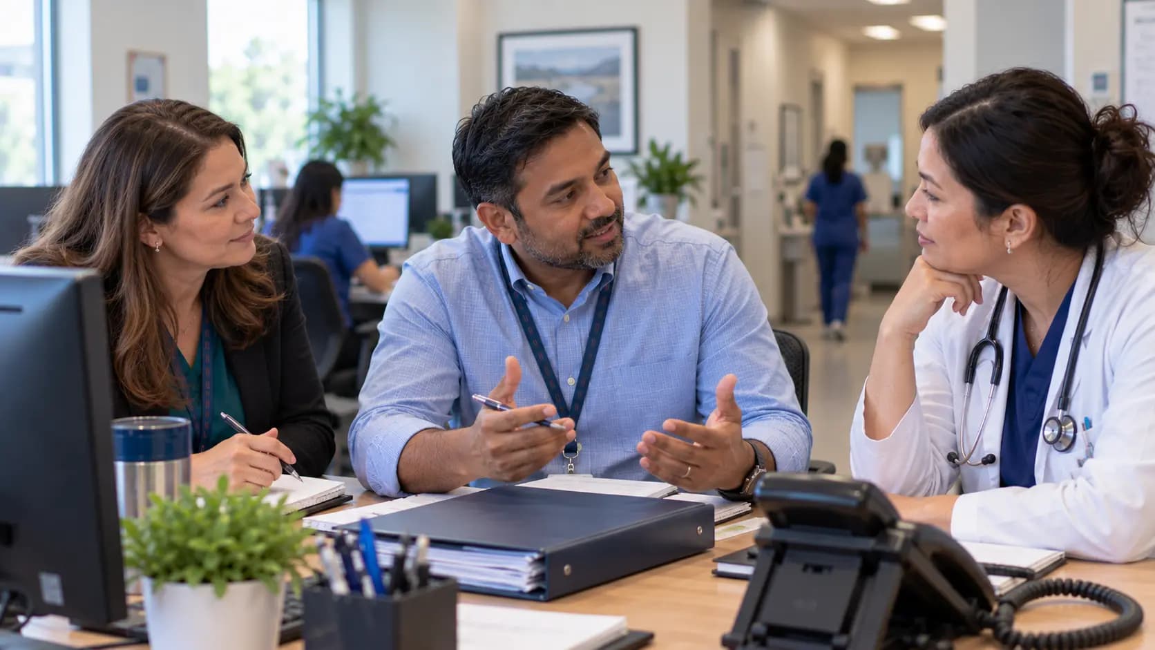 Practice manager and clinician reviewing payer requirements with a specialist