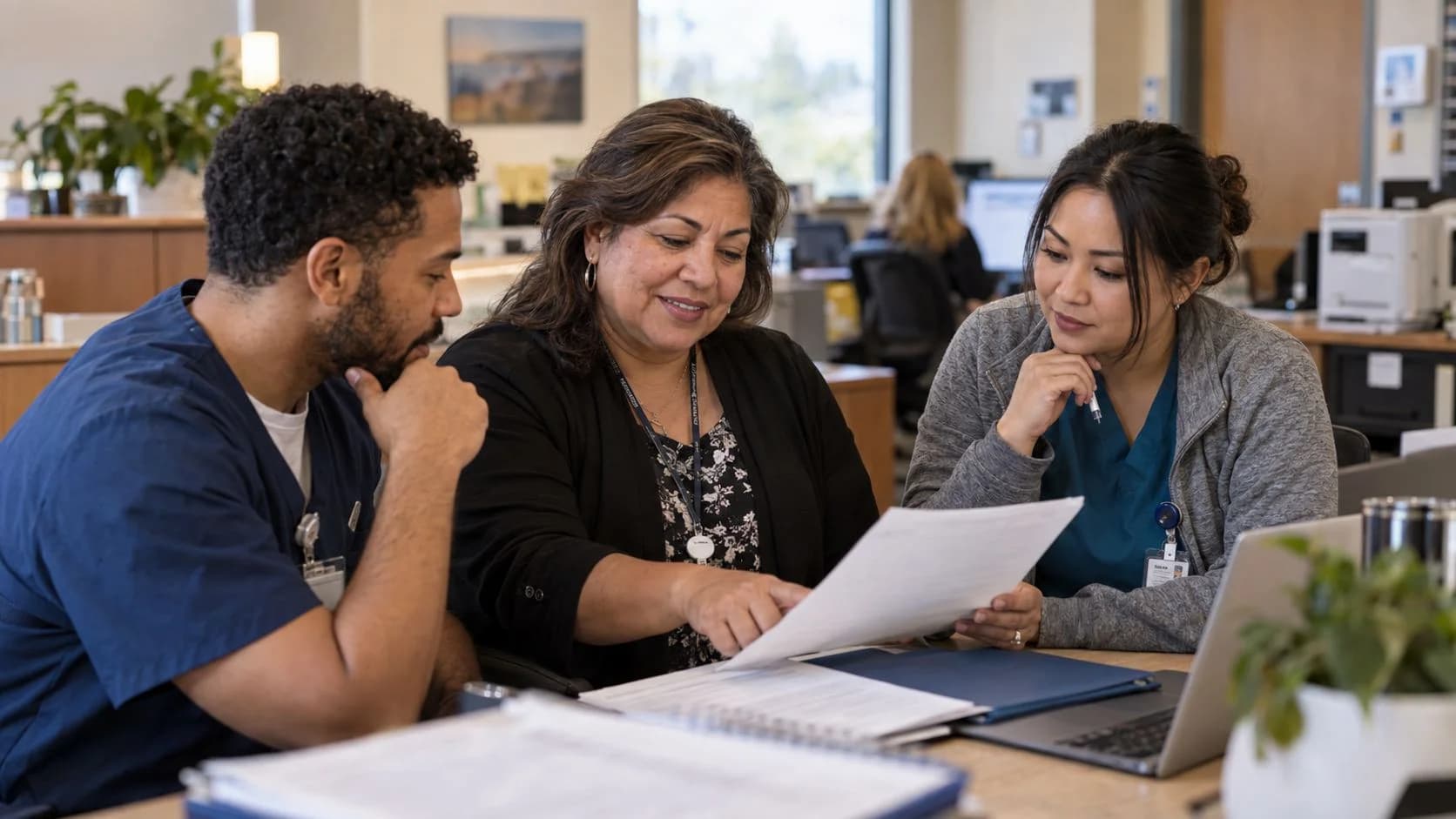 Revenue-cycle educator discussing a workflow with medical-office colleagues