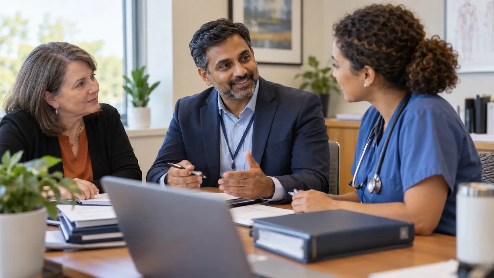 Healthcare compliance officer meeting with a clinician and practice manager
