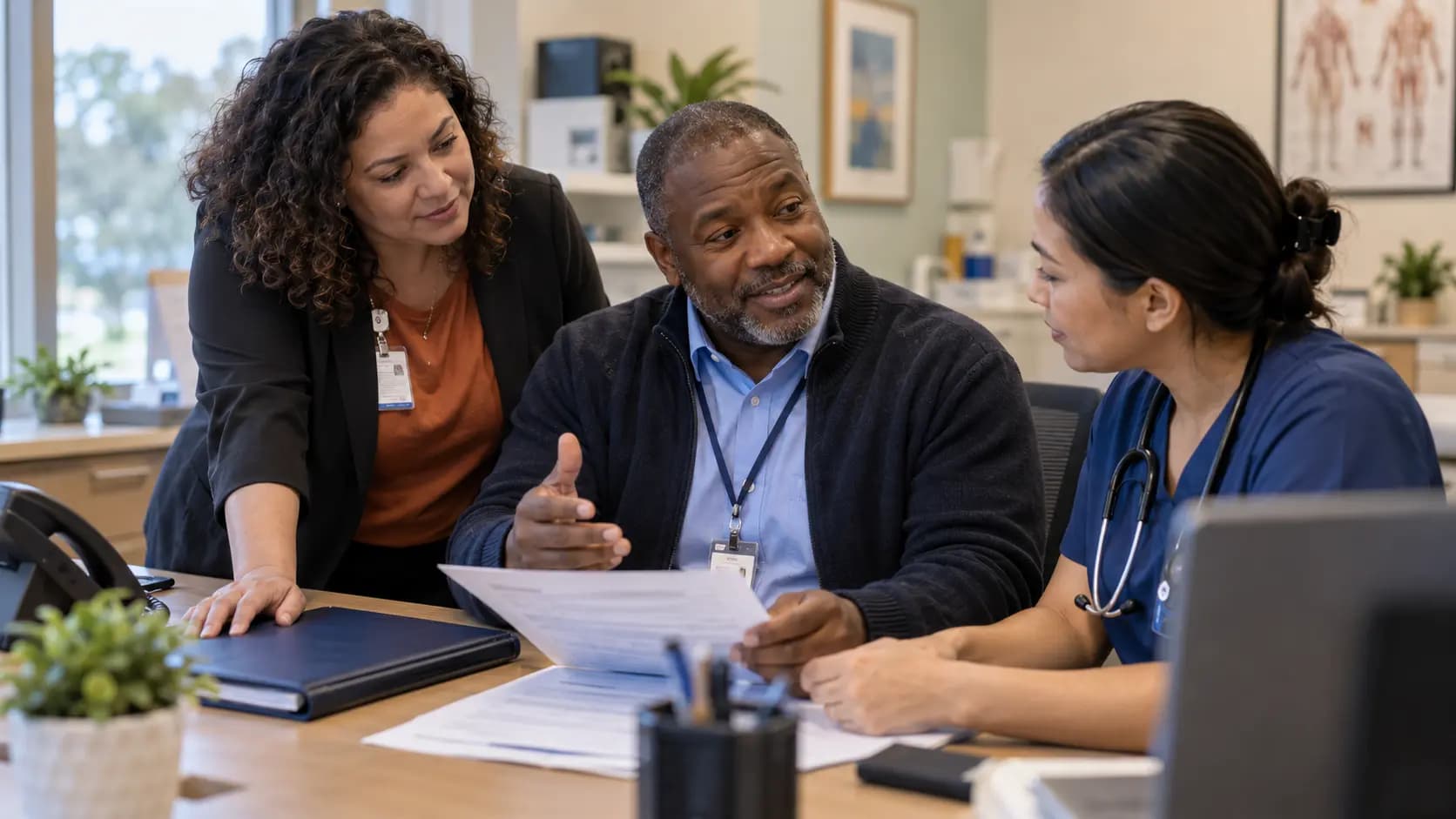 Practice manager and clinician reviewing payer requirements with a specialist