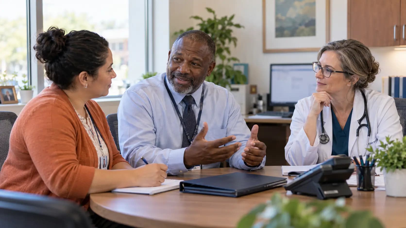 Practice manager and clinician reviewing payer requirements with a specialist