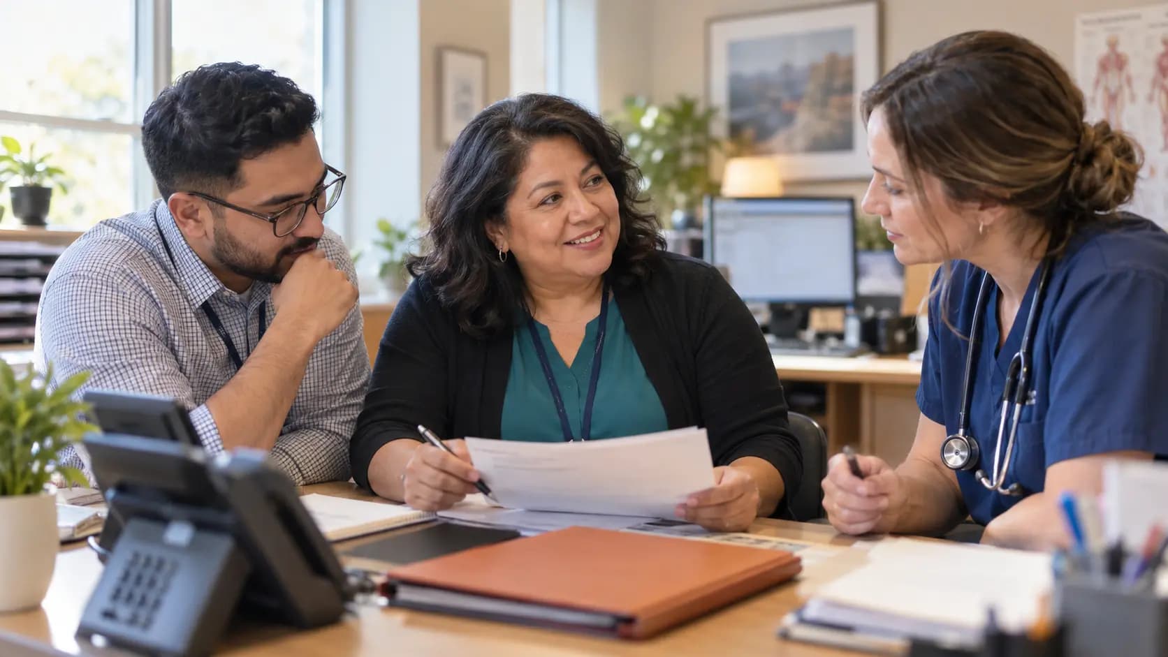 Practice manager and clinician reviewing payer requirements with a specialist