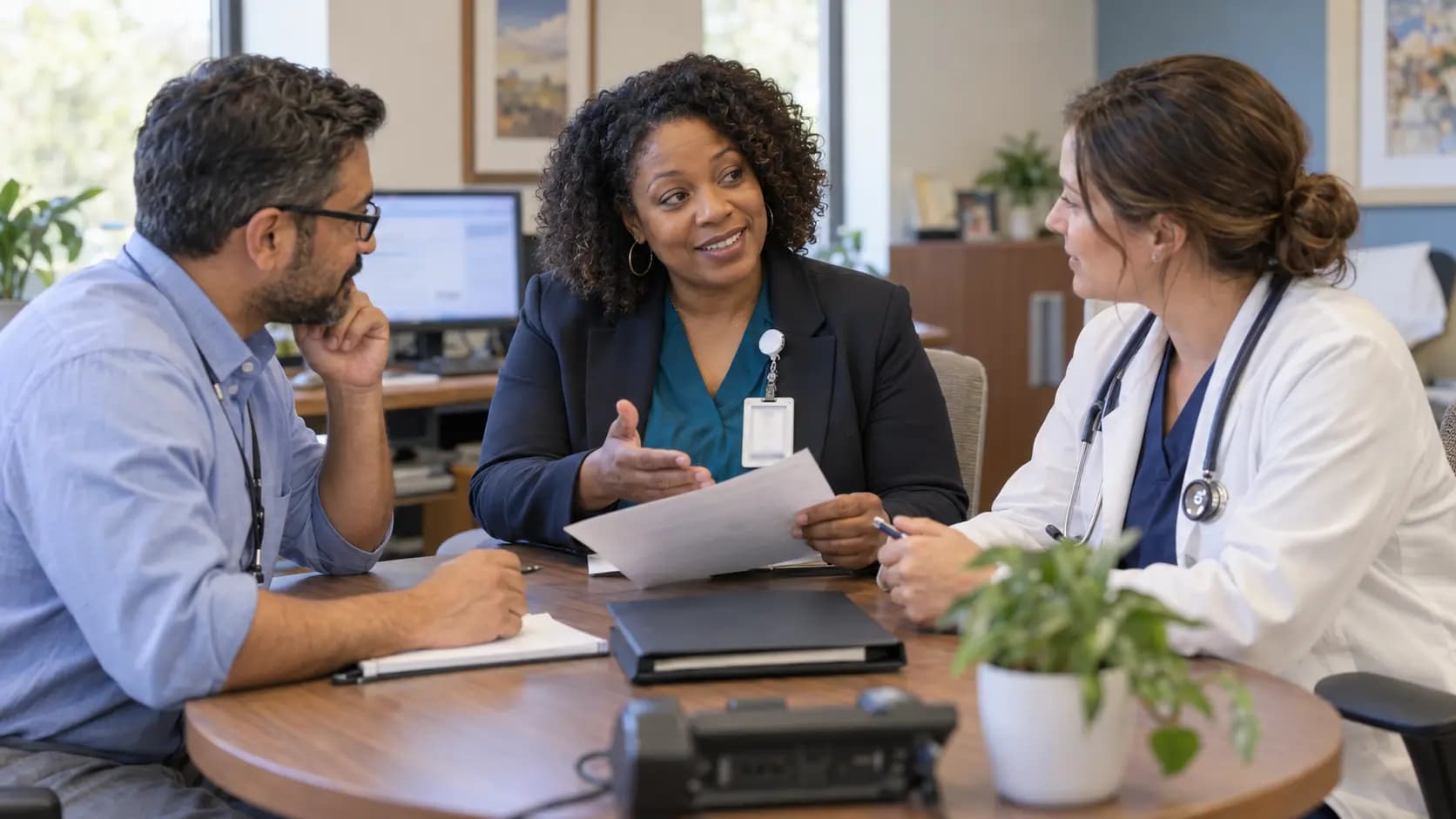 Practice manager and clinician reviewing payer requirements with a specialist