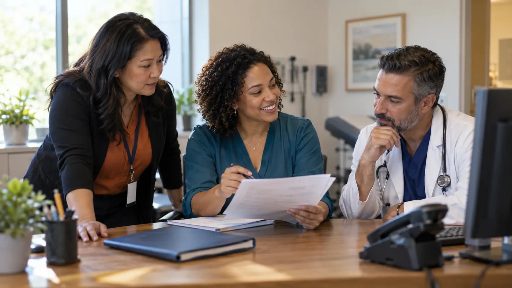 Practice manager and clinician reviewing payer requirements with a specialist