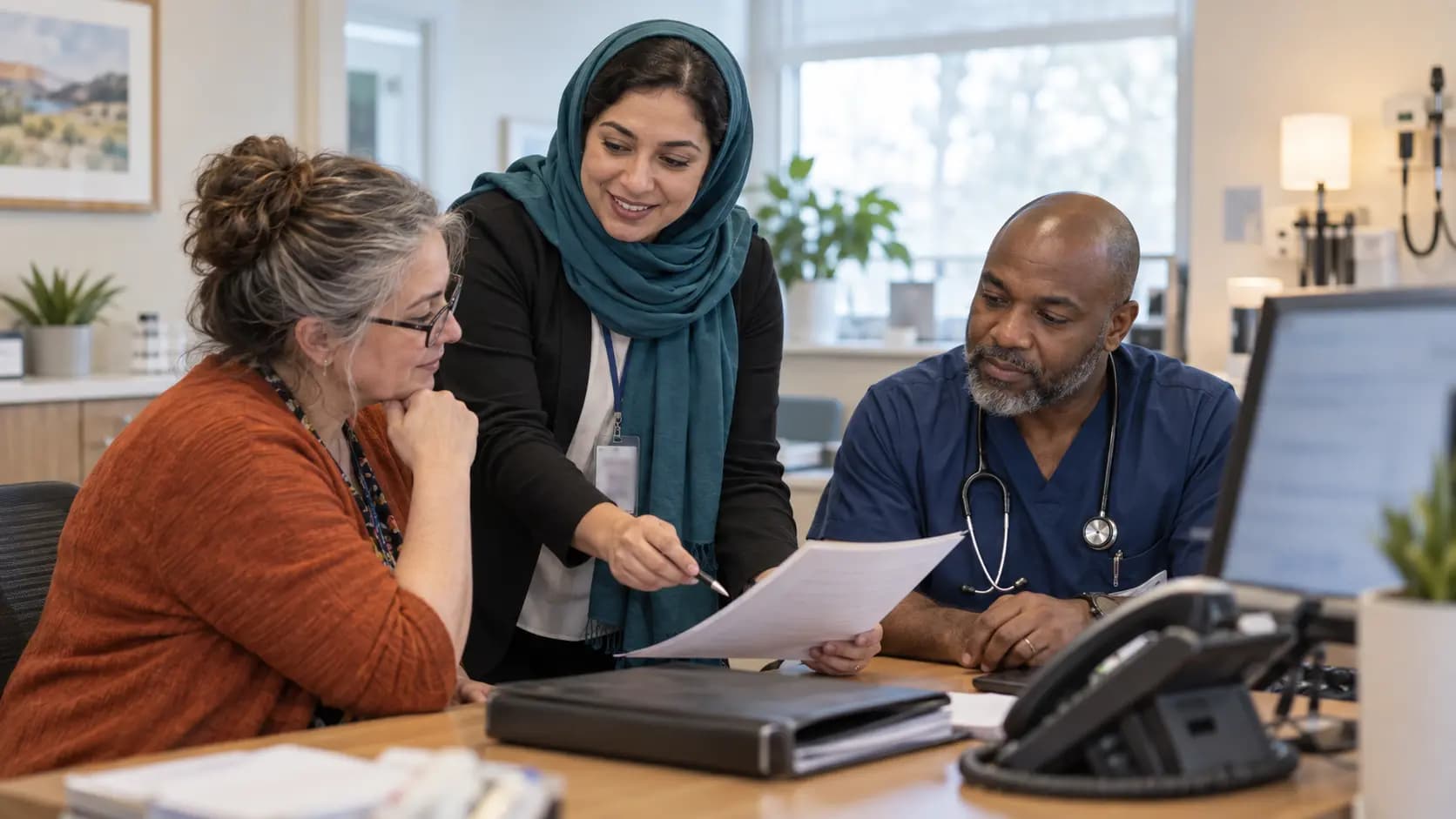 Practice manager and clinician reviewing payer requirements with a specialist