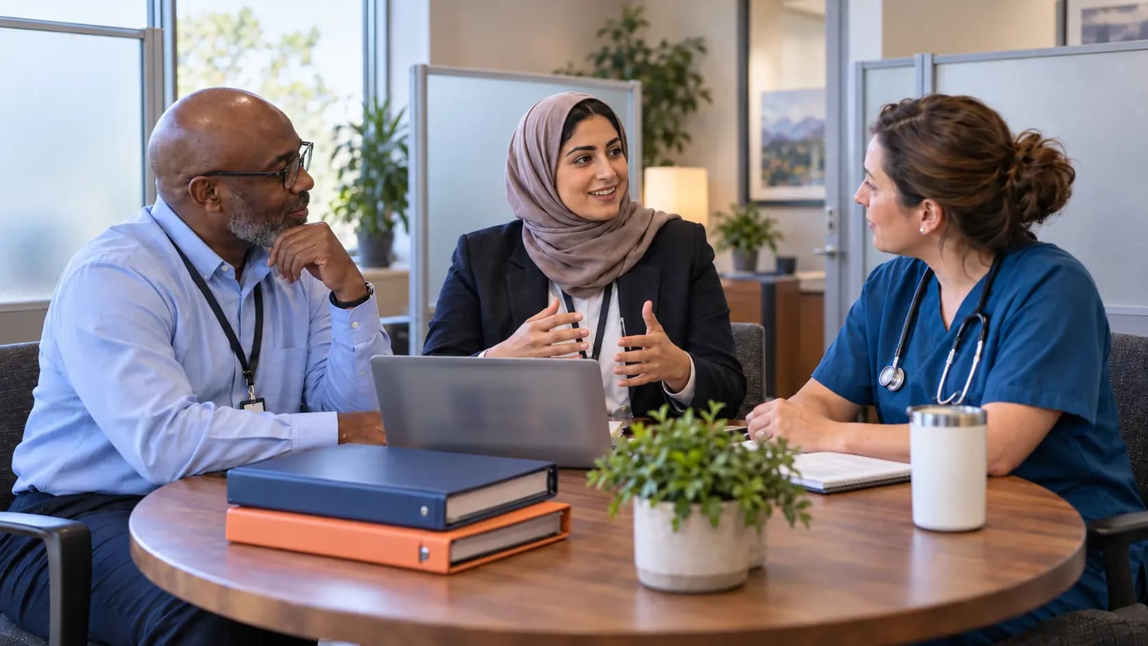 Healthcare compliance officer meeting with a clinician and practice manager