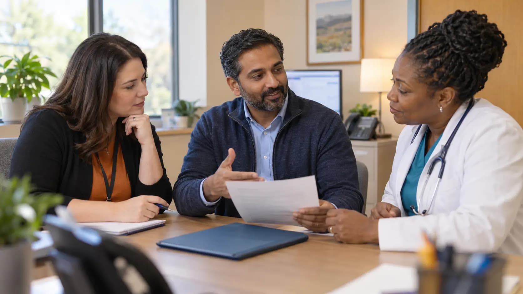 Practice manager and clinician reviewing payer requirements with a specialist