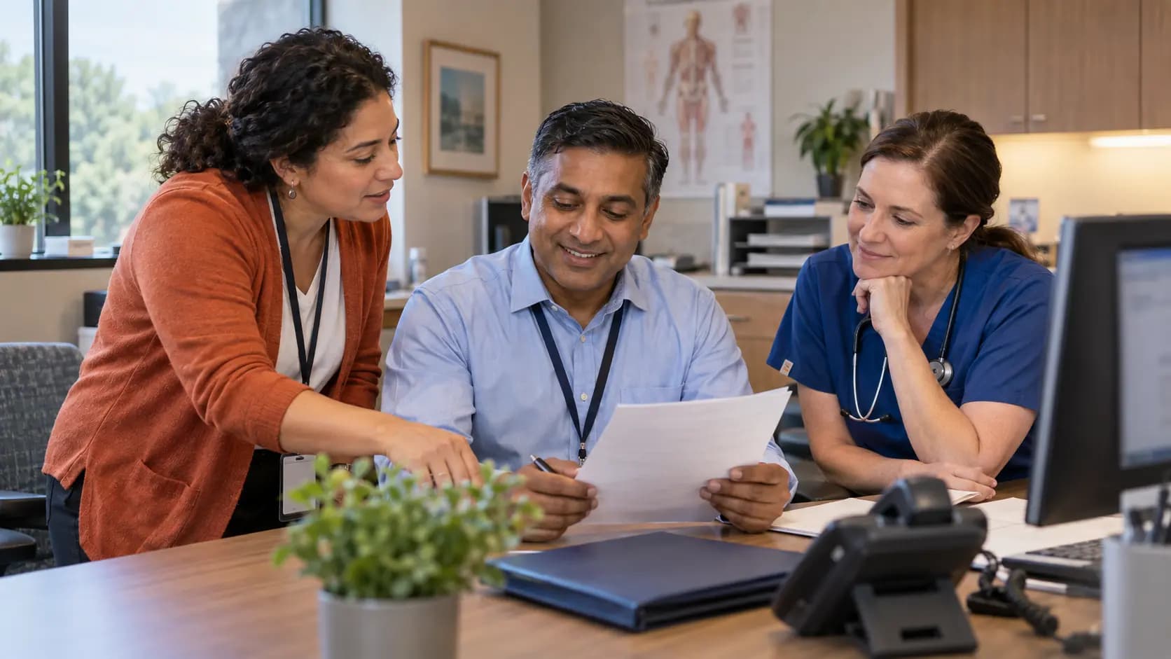 Practice manager and clinician reviewing payer requirements with a specialist
