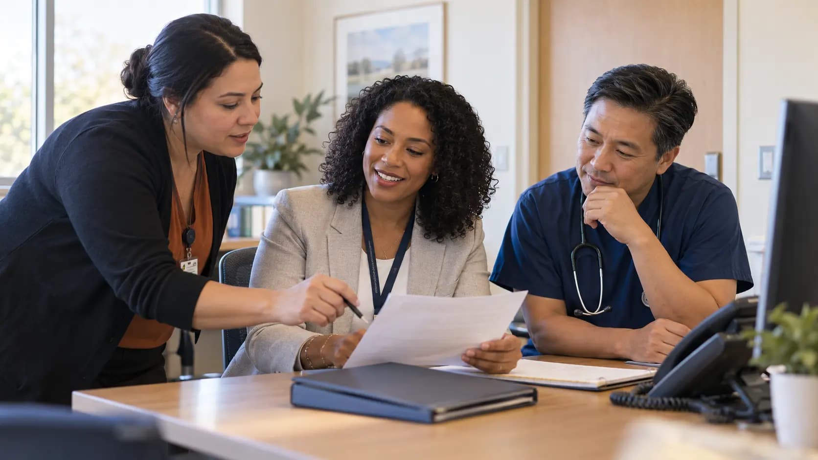 Practice manager and clinician reviewing payer requirements with a specialist