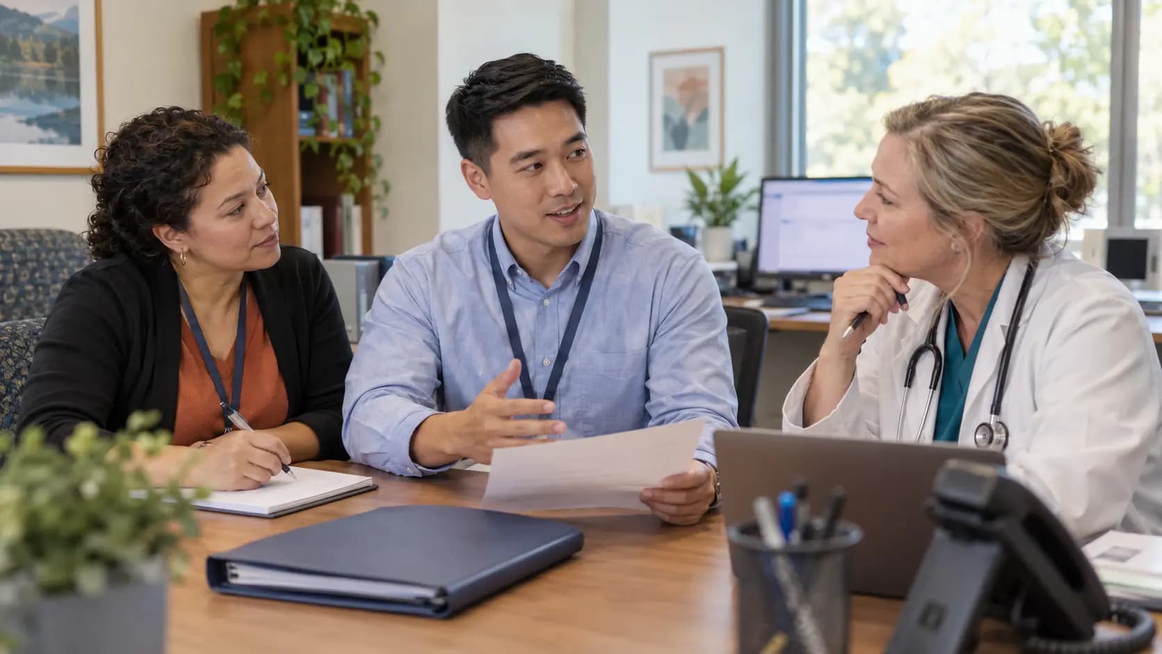 Practice manager and clinician reviewing payer requirements with a specialist