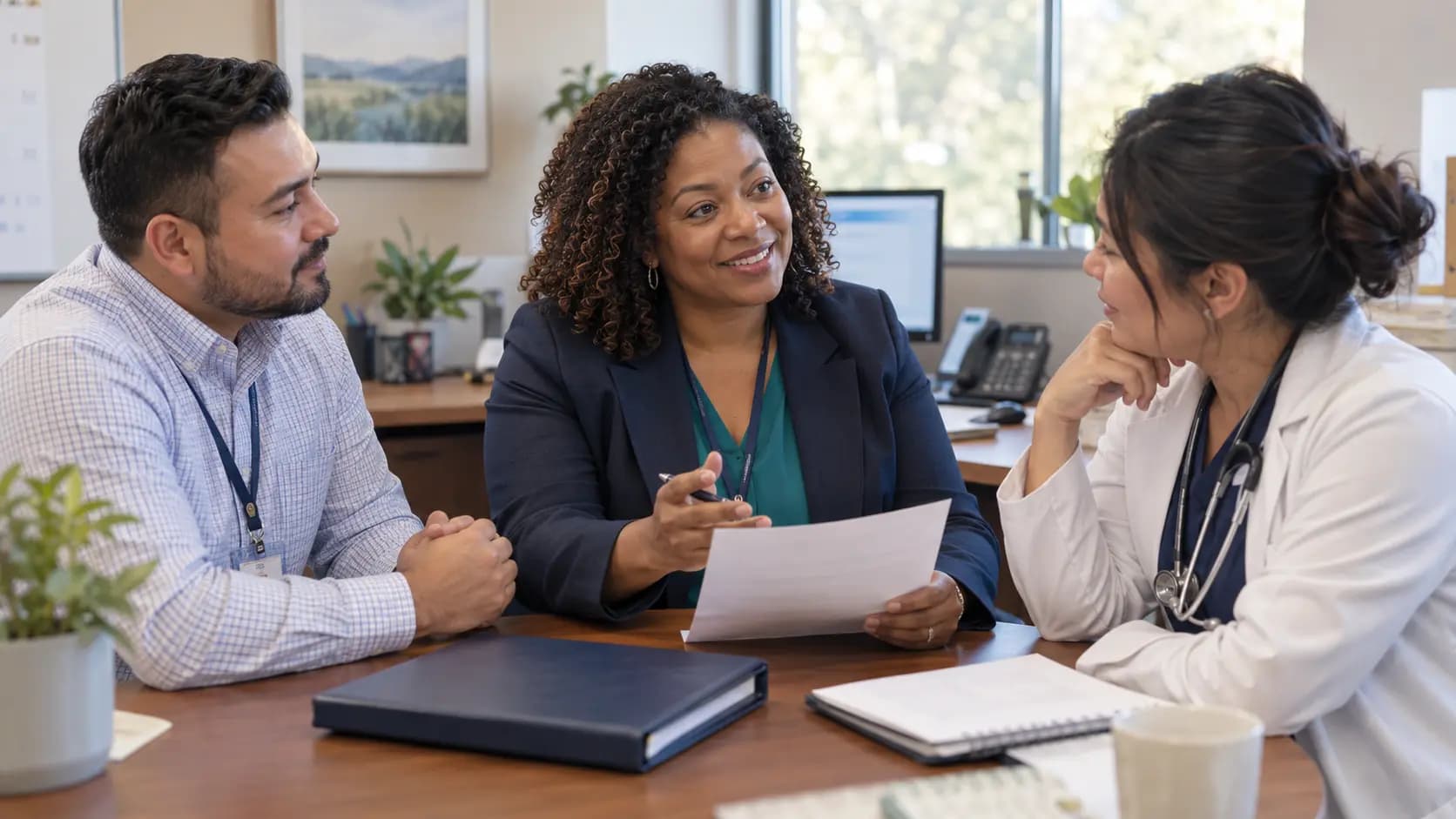 Practice manager and clinician reviewing payer requirements with a specialist