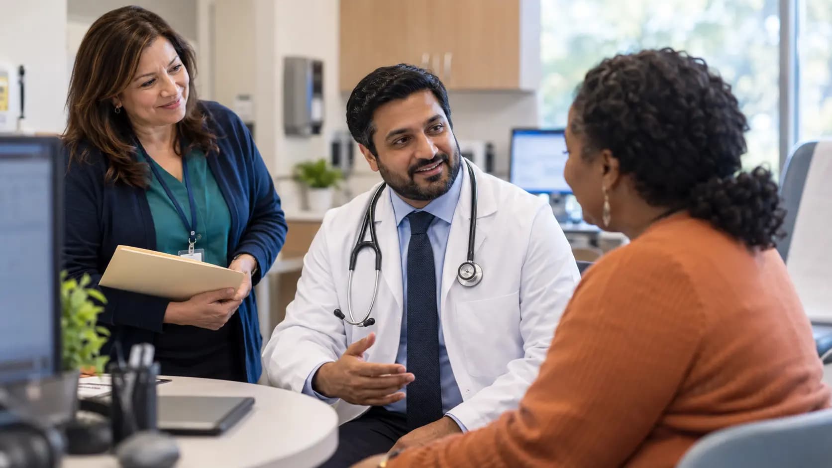 Clinician, patient, and healthcare colleague sharing a warm clinic interaction